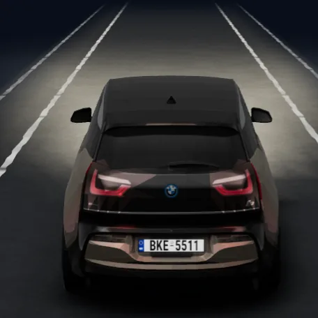 The i3 at night with its headlights on the road