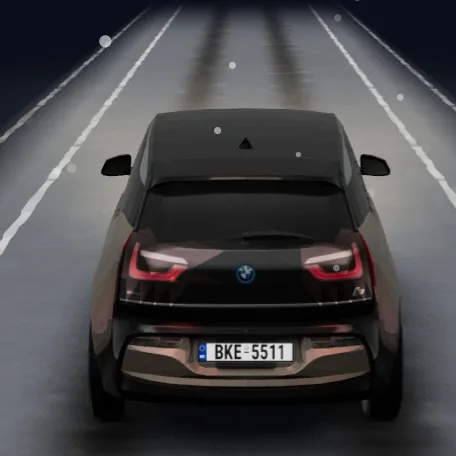The i3 on a snowy road with tyre tracks and falling snow